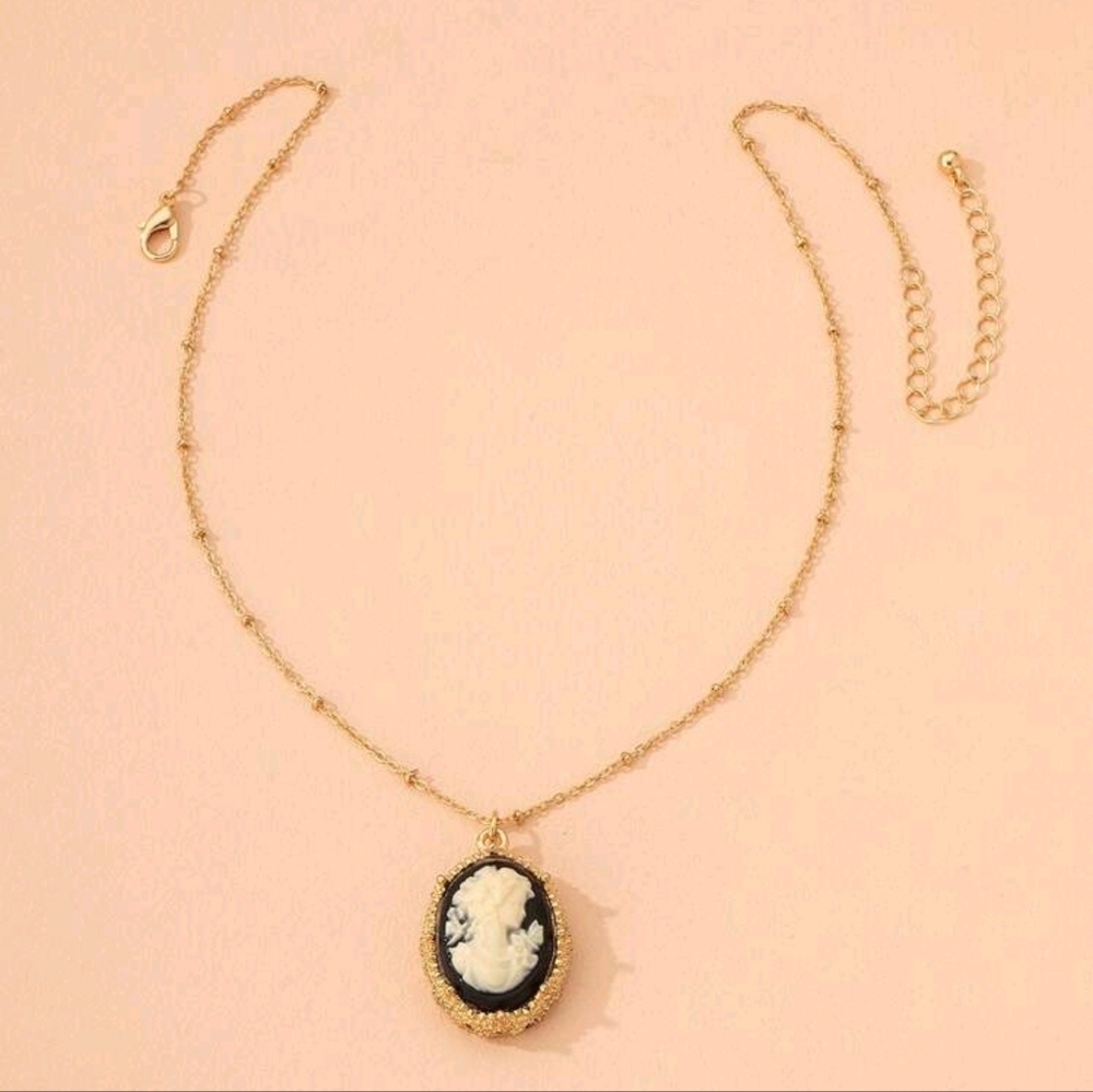 Gold cameo broach with black background